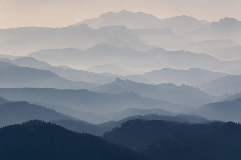 Layers of mountain ridgelines fading into pale haze